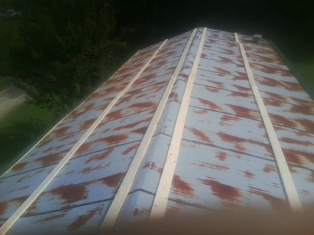 Rusted metal roof panels with new wood purlins before replacement — Storm Damage Roof Repair in Forney by Roofing Brothers