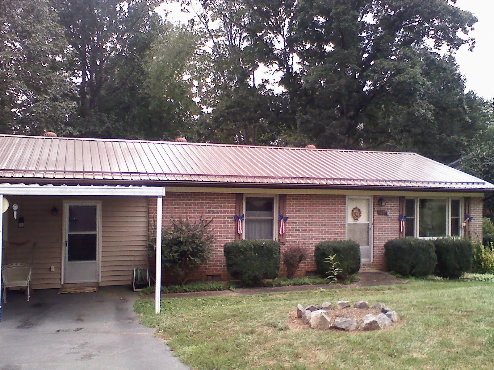 Bronze metal roof and carport on a brick ranch home — Roof Repair work by our crew in Forney